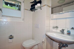 Un baño con inodoro, lavamanos y ventana.