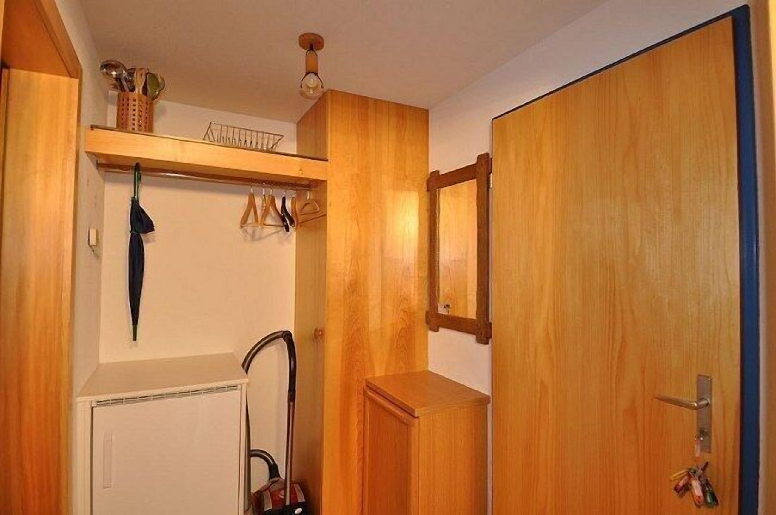 Um banheiro de madeira com porta-toalhas, espelho e radiador.