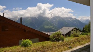 A wooden cabin with a view of snow-capped mountains and a clear sky. - Heidi 16 (Bettmeralp)