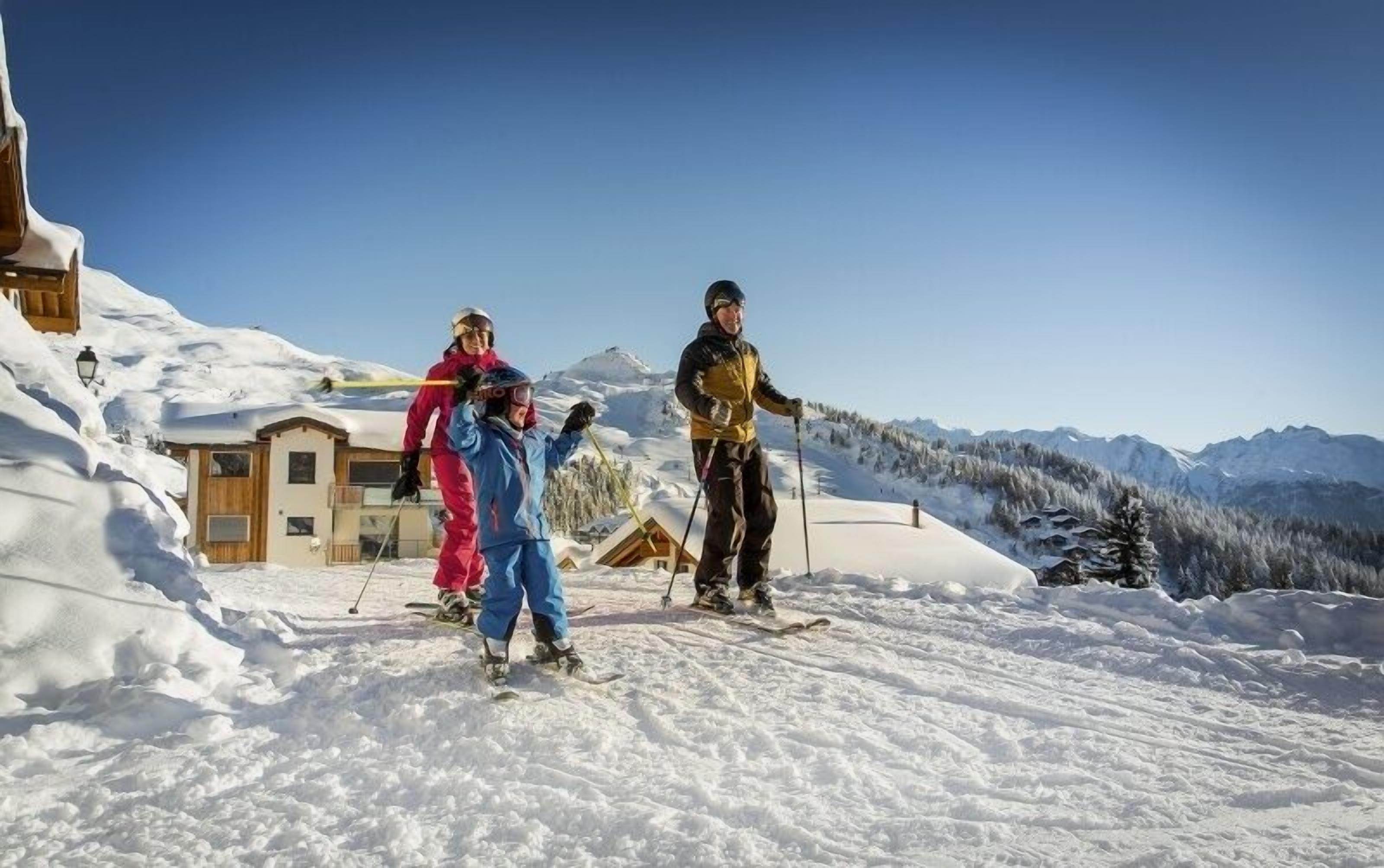 Eine verschneite Berglandschaft mit einer Holzhütte und einem Skihotel.