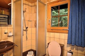 A bathroom with a shower, toilet, and sink.
