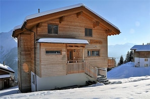 A wooden chalet with a balcony, a sign reading "L'uckershof", and a snowy mountain backdrop. - Laackerhof (Bettmeralp)