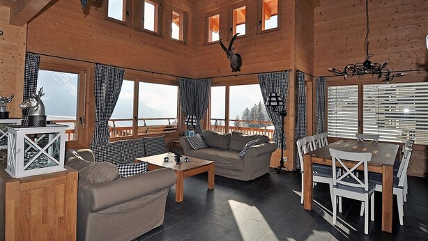 Ein gemütliches Blockhausschlafzimmer mit einer Couch, einem Couchtisch und einem Esstisch.