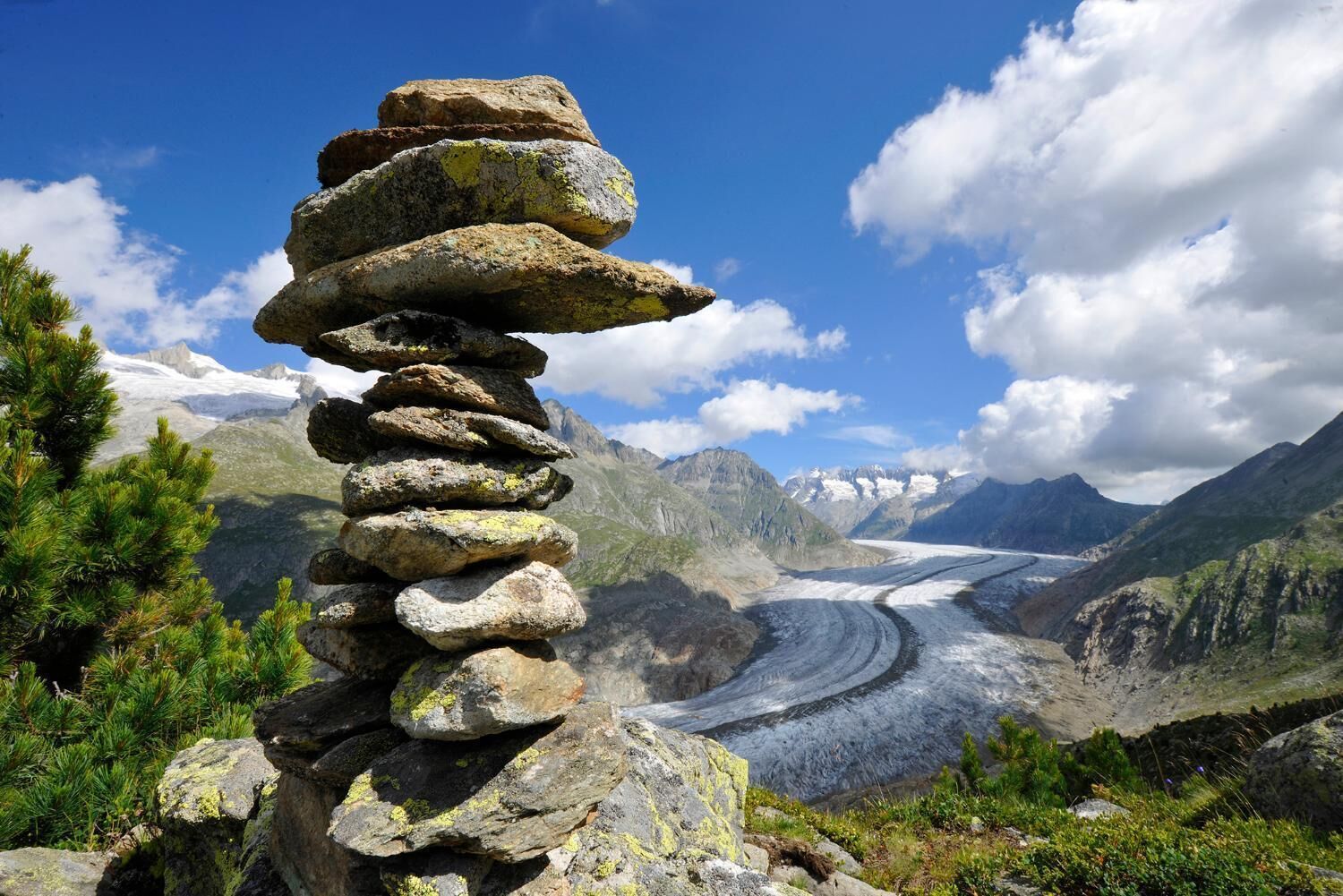 Eine Ansammlung von Steinen in einer Bergregion, im Hintergrund ein Gletscher.