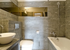 A modern bathroom with a freestanding bathtub, a round sink, and a toilet. - Rupicapra (Bettmeralp)