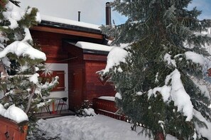 A wooden cabin with a snow-covered roof and a chimney. - Sternschnuppe OG (Bettmeralp)
