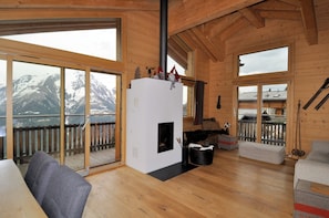 A wooden cabin with a fireplace, a balcony with a view of mountains, and a ski rack. - t'Alpa (Bettmeralp)