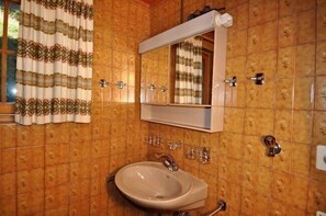 A bathroom with a sink, mirror, and patterned tiles. - Toggi EG (Bettmeralp)