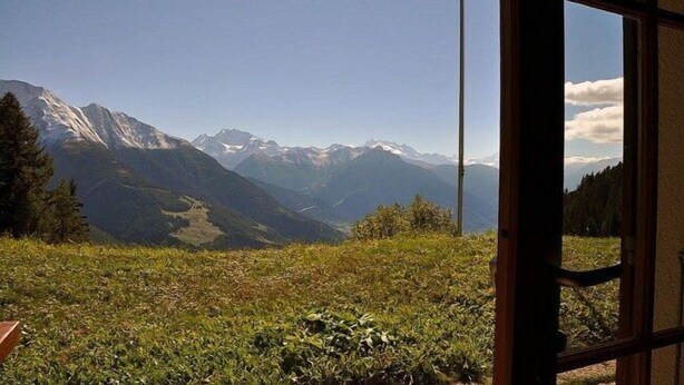 Una habitación con un amplio ventanal que ofrece vistas a la montaña.
