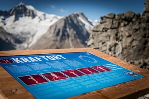 An informational sign about KRAFTORT with a mountainous background.