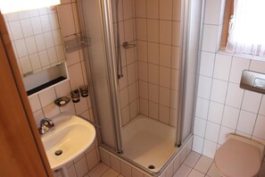 A bathroom with a shower, sink, and toilet.