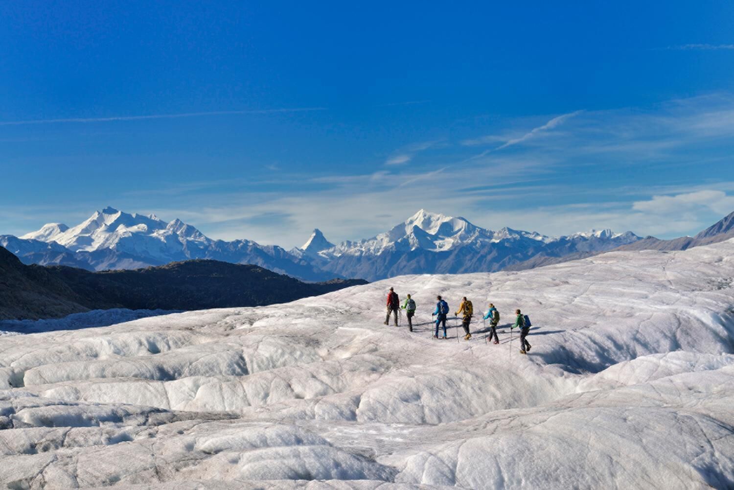 Ein Gletscher, auf dem eine Gruppe Wanderer unterwegs ist.