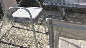 Une table et deux chaises dans un jardin avec vue sur la montagne.