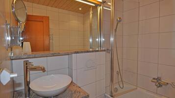 Ein Badezimmer mit Waschbecken, Spiegel und Dusche.