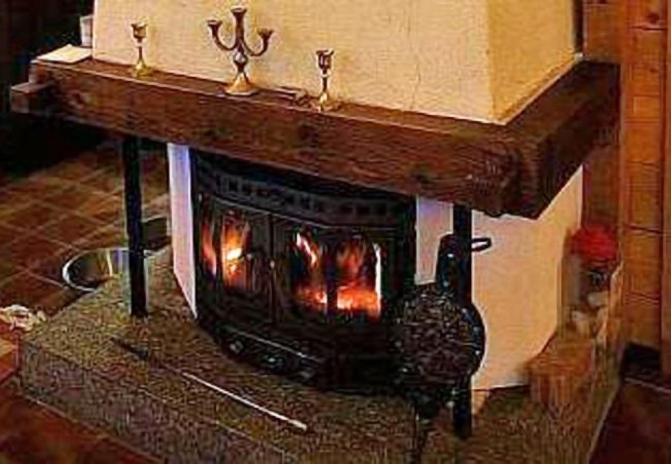 A fireplace with a mantel and three candles.