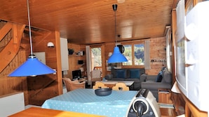 A cozy cabin interior with a dining area, a sofa, and a kitchen. - Uf der Egga 419 (Fiesch)