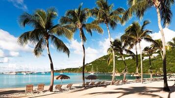 Rannalla, aurinkotuoleja, rantapyyhkeitä