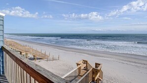 Una pasarela de madera que conduce a una playa de arena con vistas al océano.