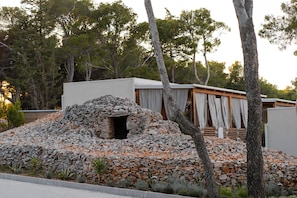 A modern building with a stone wall and a wooden deck.