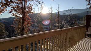 Un balcon offrant une vue sur un paysage montagneux et un ciel dégagé.