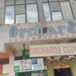 En bygning med skilte for 'Orchard's Accommodation' og 'Orchards Club'.