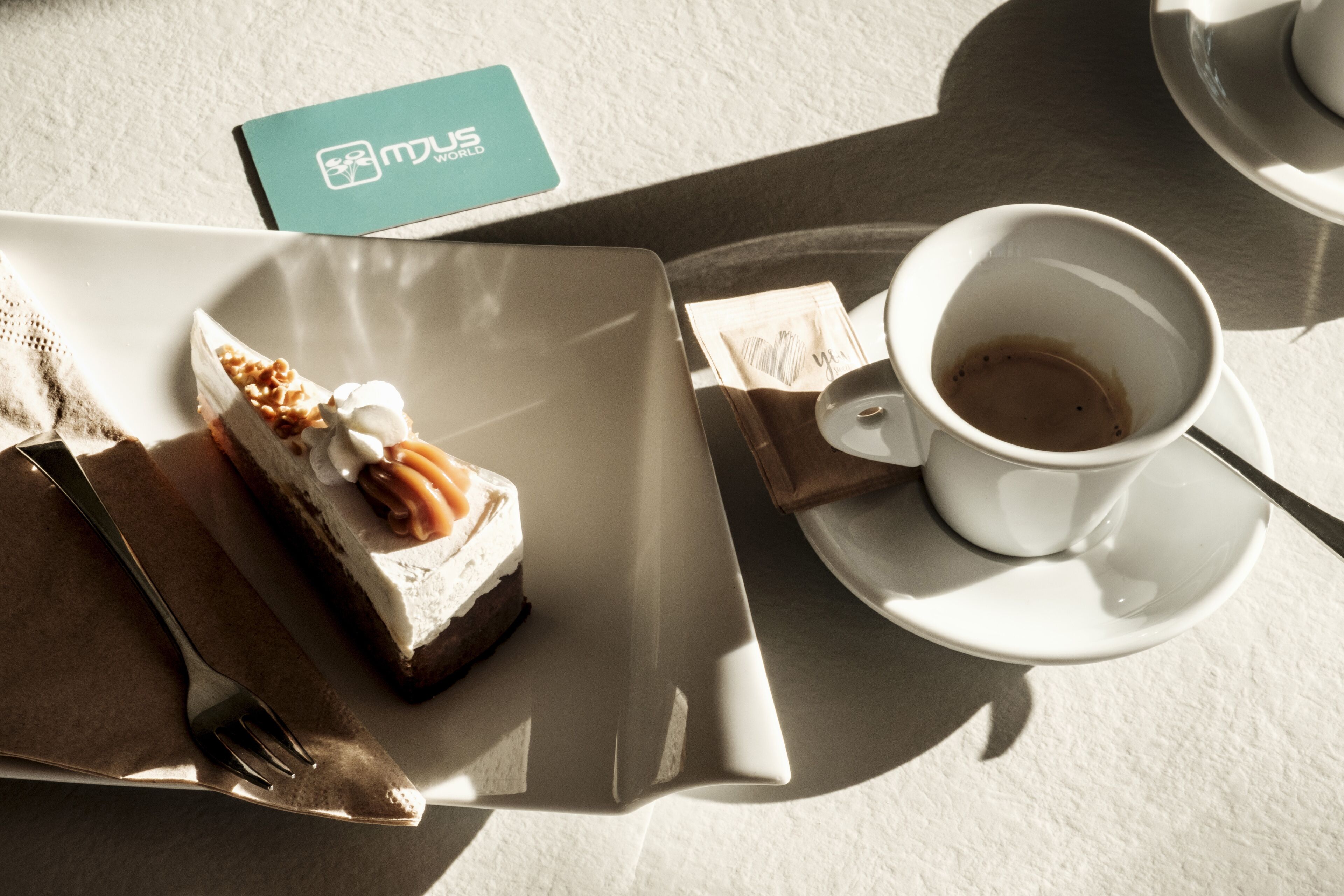 A dessert plate with a slice of cake and a cup of coffee on a table.