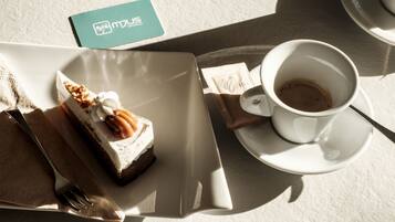 A dessert plate with a slice of cake and a cup of coffee on a table.