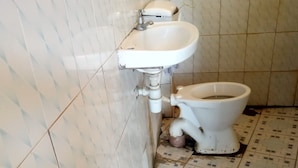 Un baño con inodoro, lavamanos y paredes de azulejos.