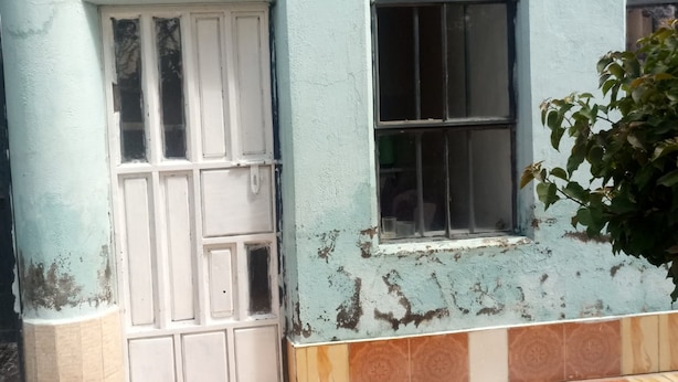 Un edificio con recepción, piso de baldosas y una ventana con barrotes.