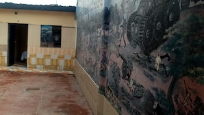Un edificio con suelo de baldosas y un mural en la pared que representa escenas militares.