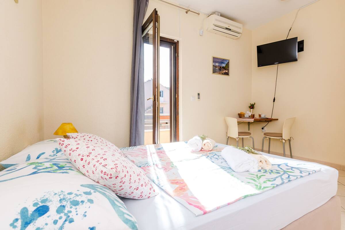 Une chambre d’hôtel équipée d’un lit, d’un bureau, d’une chaise, d’une télévision et d’un appareil de climatisation.