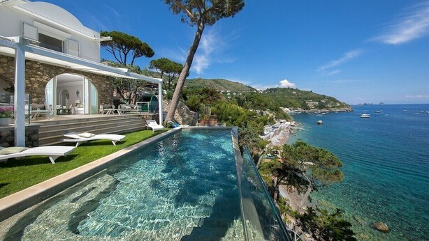 Une villa moderne dotée d’une piscine à débordement privée offrant une vue imprenable sur la côte.