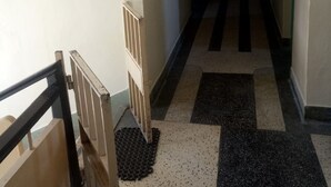 A long, narrow hallway with a patterned floor and a handrail on the left. - Top Lodge (Naivasha)