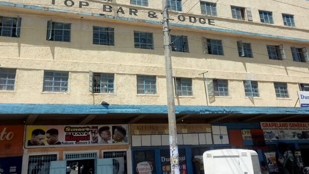 A multi-story building with a sign reading "TOP BAR & LODGE". - Top Lodge (Naivasha)