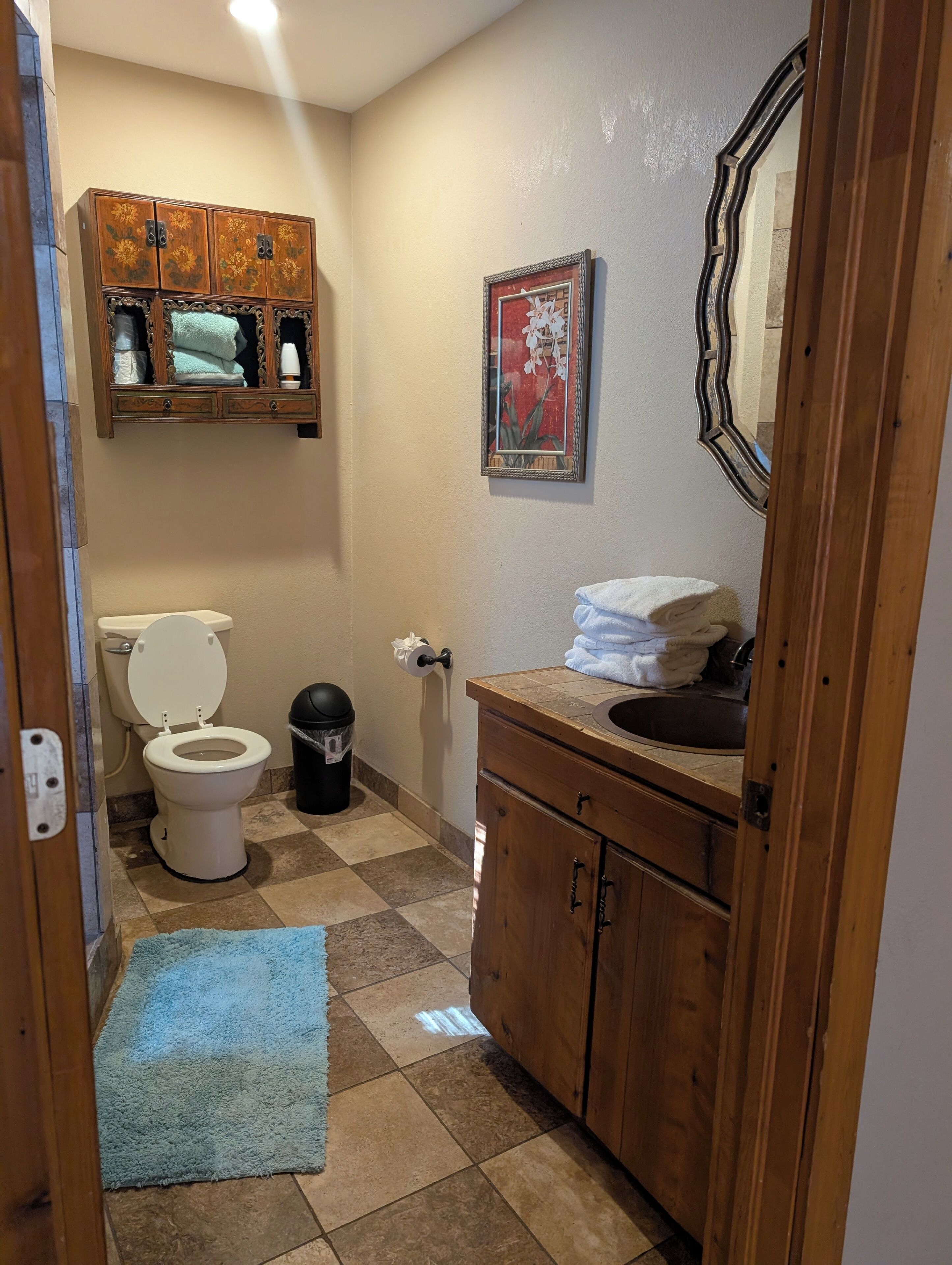 Un baño con inodoro, lavabo, tocador y espejo.