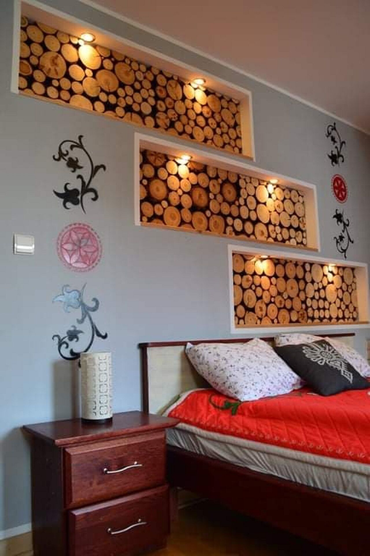 Ein Schlafzimmer mit einem Bett, einem Nachttisch und einer Wandablage mit Holzscheiten.