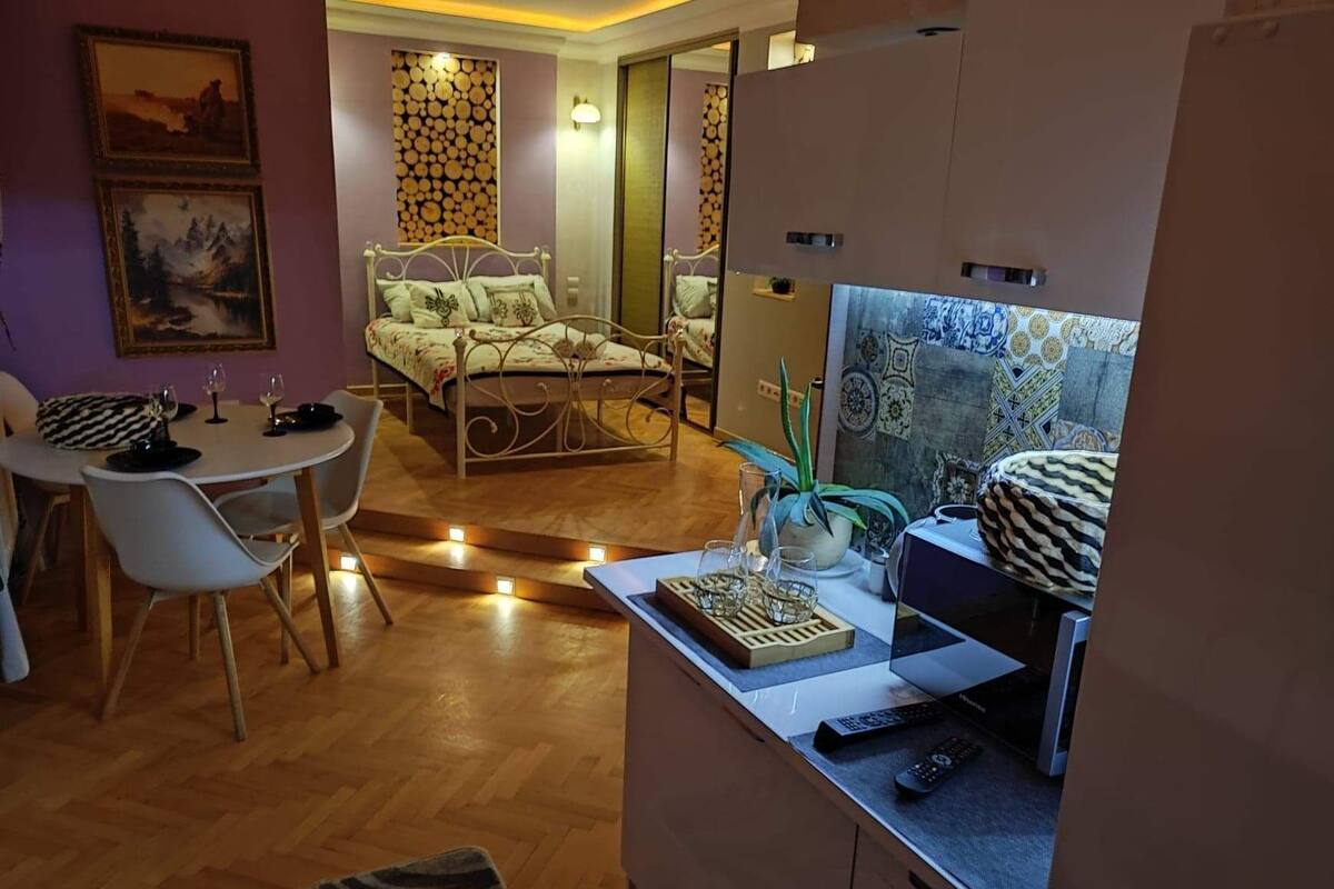 Ein gemütliches Wohnzimmer mit Bett, Essbereich und Küchenzeile.