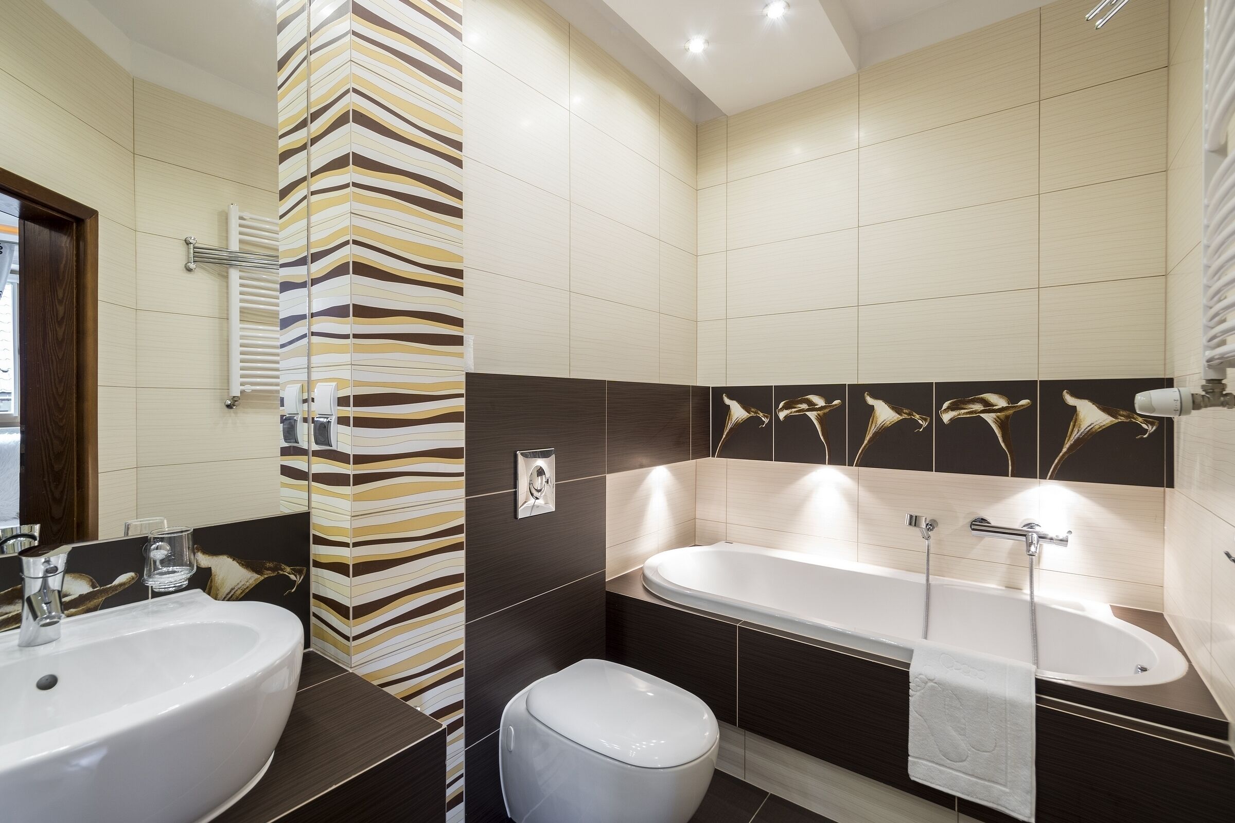 A modern bathroom with a large bathtub, a sink, and a toilet.