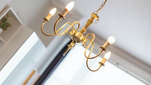 A chandelier with multiple arms and lights, hanging from a chain.