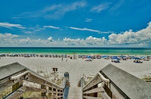 A beach with a wooden staircase leading down to the sand, a clear sky, and a calm sea. - ALERIO UNIT B301 for 8 Guests with Pool & Jacuzzi (Miramar Beach)