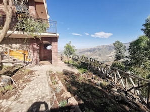 A stone building with a wooden staircase leading to a balcony. - Lalibela Apartments (Lalibela)