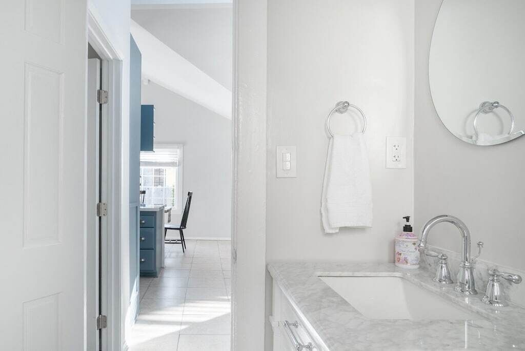 Une salle de bain moderne avec un double vasque, un grand miroir et un porte-serviettes.