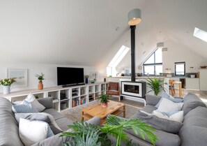Relax in this spacious living room with a sofa, coffee table, and fireplace, perfect for unwinding.