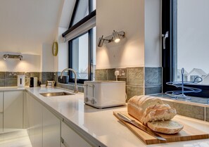 Enjoy meal preparation in this well-equipped kitchen with a large window, toaster, and modern sink.