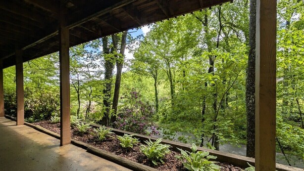 A covered walkway with a view of a forested area. - Williams House at Lake Junaluska -Spacious 5-Bedroom Family Retreat (Lake Junaluska)