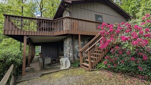 A cabin with a wooden deck, a staircase, and a stone wall. - Williams House at Lake Junaluska -Spacious 5-Bedroom Family Retreat (Lake Junaluska)