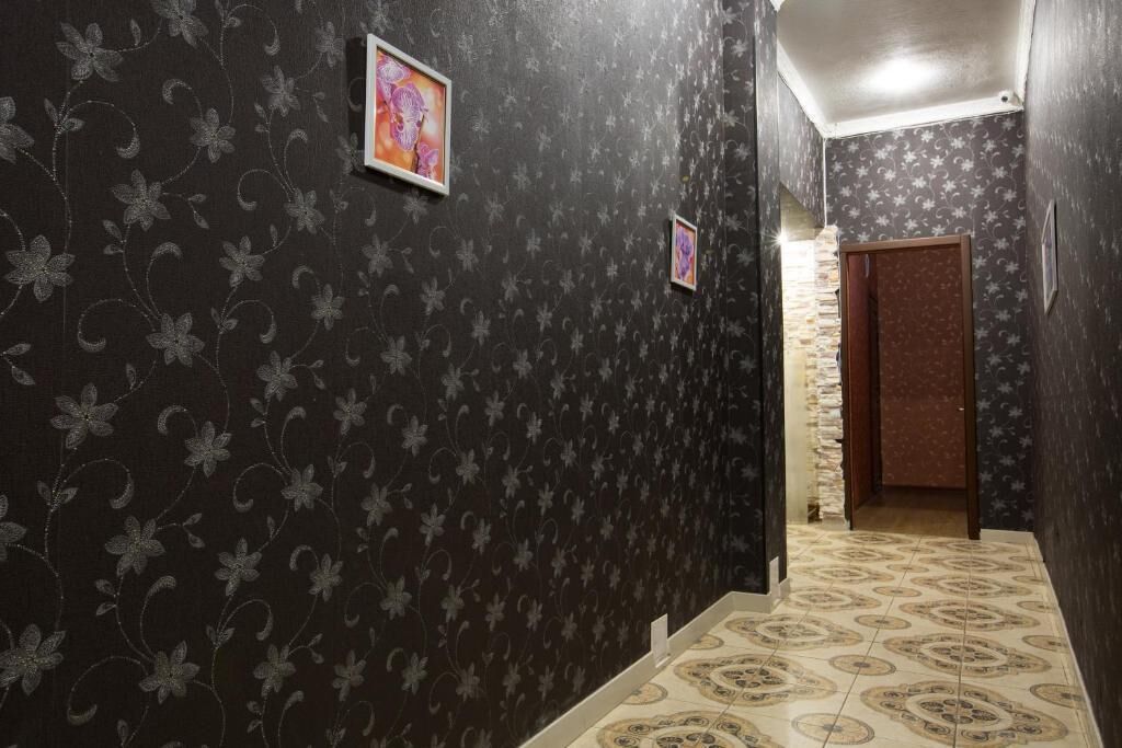 Un couloir avec un papier peint à motifs et des carreaux de sol à motifs.