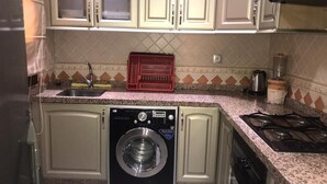 Appartement | Privékeuken | Een koelkast met diepvriezer, een oven, een kookplaat