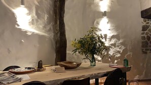 En matplats med ett långt bord, en vas med blommor, en trävase och en flaska handsprit.
