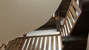 En trätrappa med ett sluttande tak och utsikt över våningen ovanför.